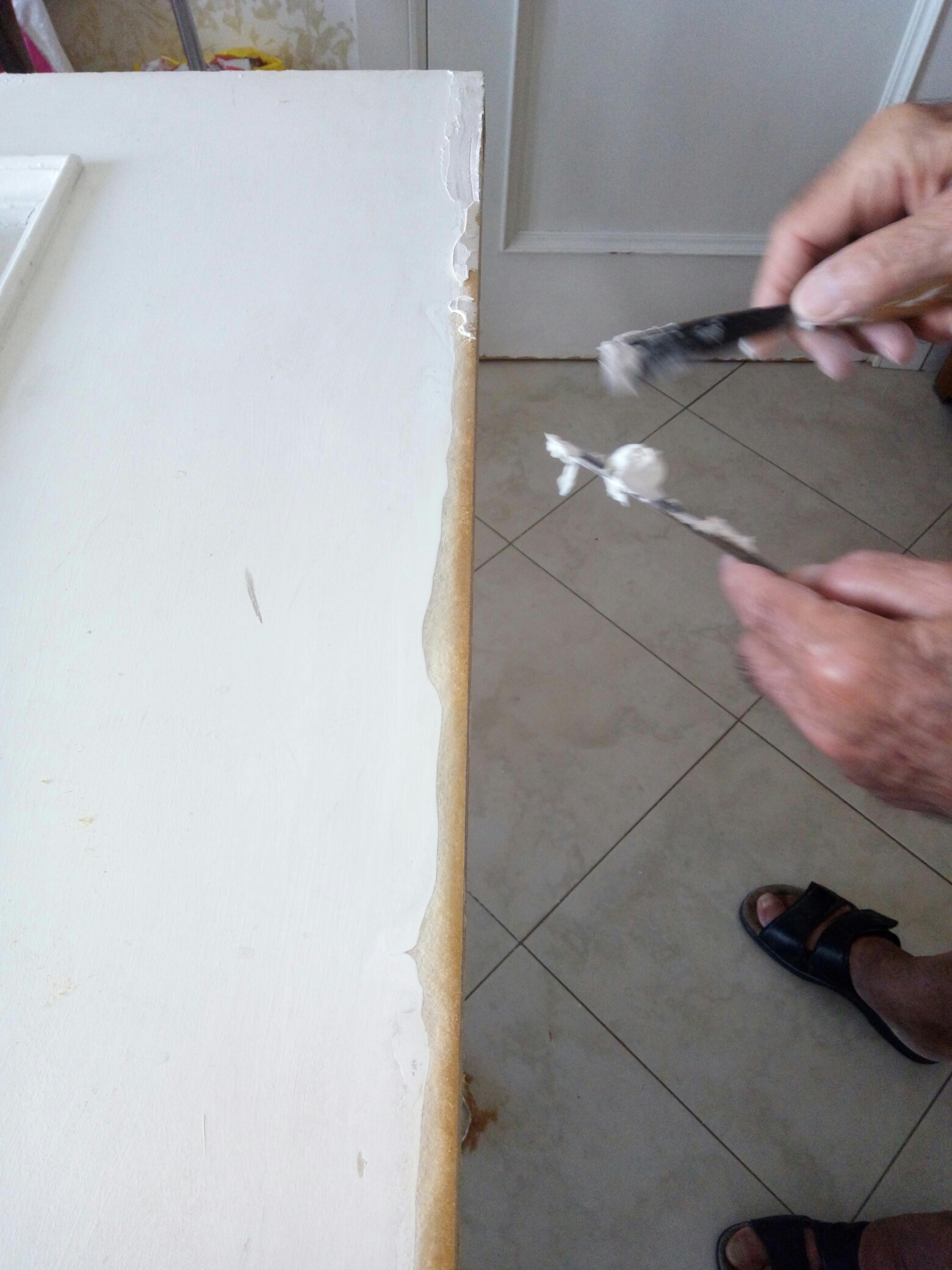 Procedere alla stuccatura. Tale operazione, necessaria per la successiva fase della tinteggiatura dell'intera porta, consente anche l'irrigidimento degli strati di Mdf, molto utile per l'incollaggio delle cornici