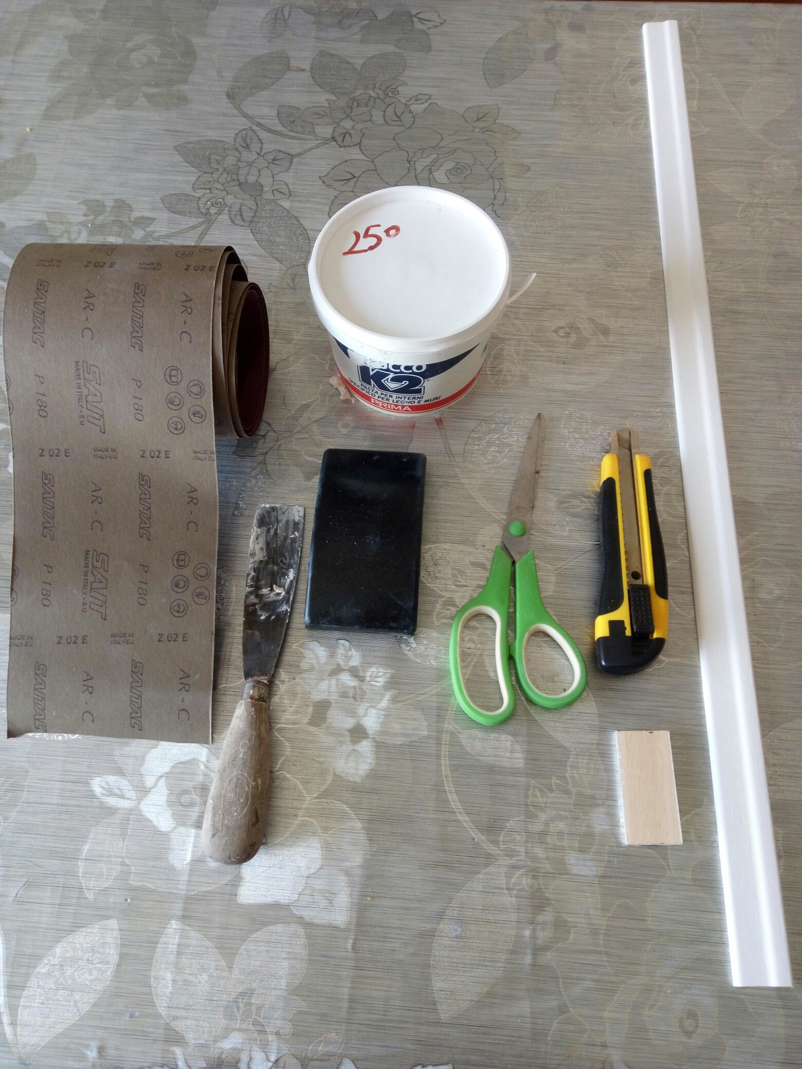 Carta abrasiva di tipo fine ma resistente; Supporto gommato per carta abrasiva; Cutter con lama grande professionale (taglierino); Forbici; Stucco per legno; Metro; Cornice a piacere. Carta abrasiva di tipo fine ma resistente; Supporto gommato per carta abrasiva; Cutter con lama grande professionale (taglierino); Forbici; Stucco per legno; Metro; Cornice a piacere.